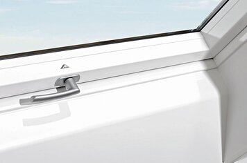 Nahaufnahme eines Dachfensters von innen mit Fenstergriff. Roto Logo über dem Fenstergriff zu sehen. 