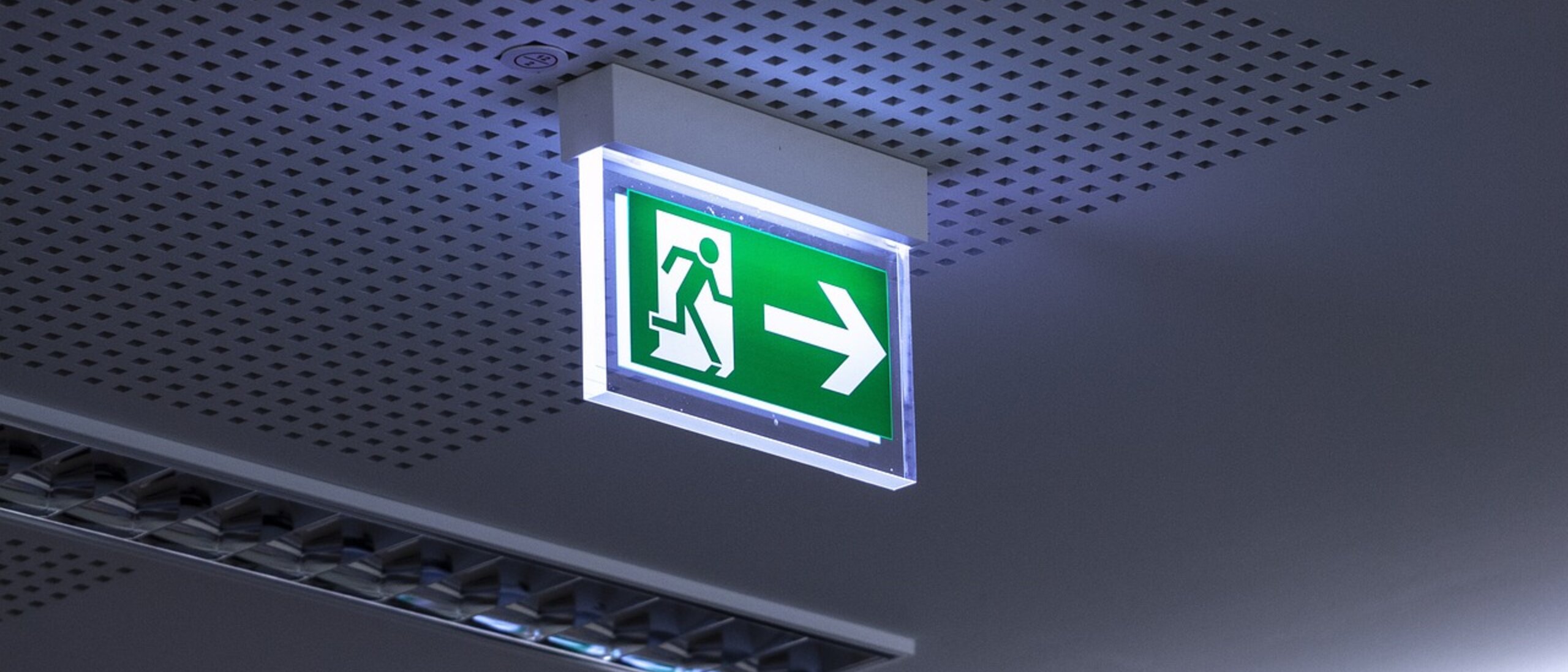 Ein Schild an der Decke. Es kennzeichnet den Fluchtweg im Notfall.