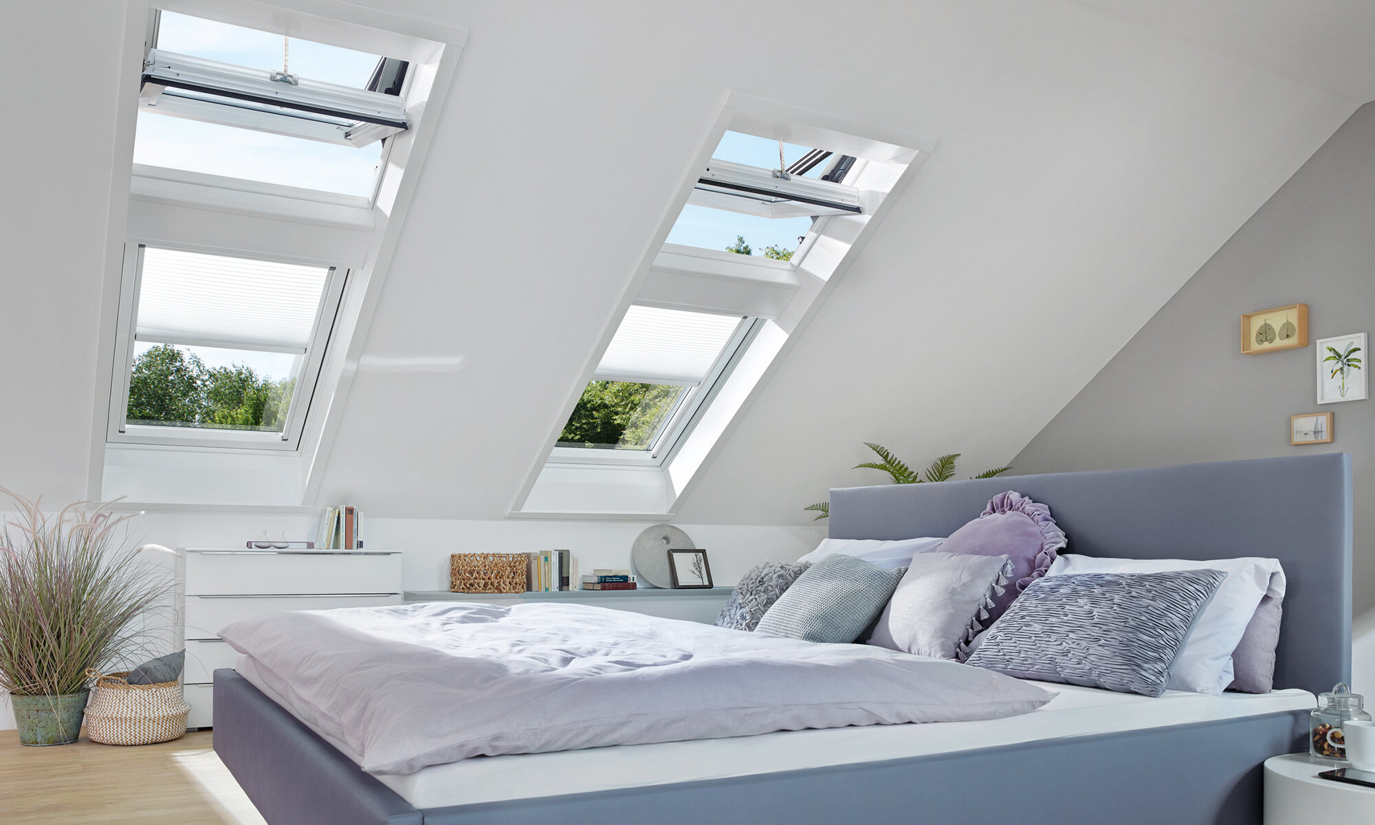 Schlafzimmer mit vier großen Dachfenstern, bei den jeweils zwei übereinander stehen. Die oberen Dachfenster sind geöffnete Schwingfenster.