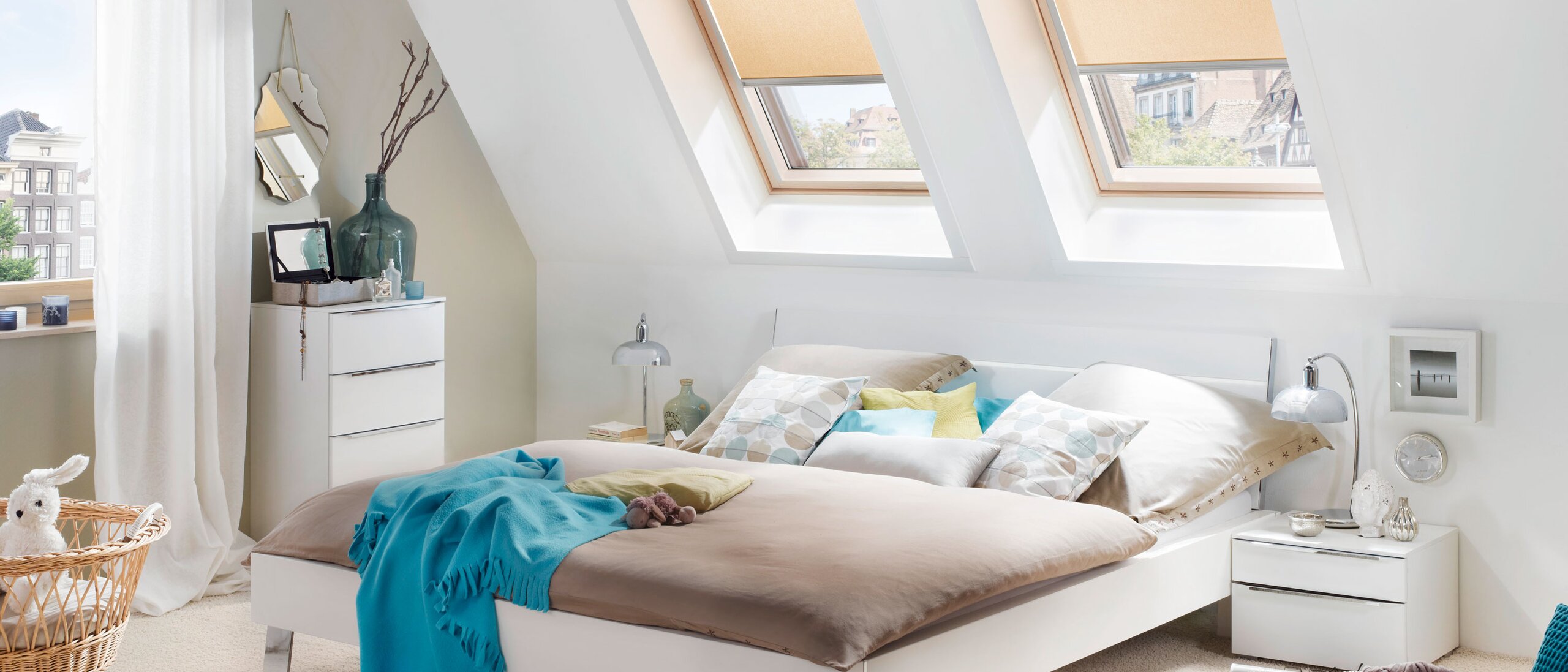 Ein Schlafraum mit Dachfenster an denen Rollos befestigt sind. 