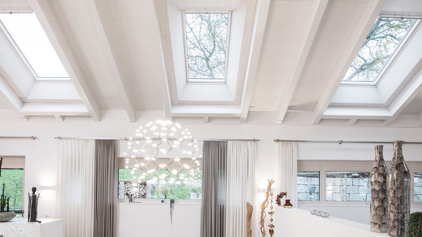 Wohnzimmer mit schrägen Deckenfenstern. 