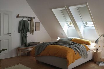 Schlafzimmer mit Dachfenster welches mit Verdunkelungsrollo ausgestattet ist.